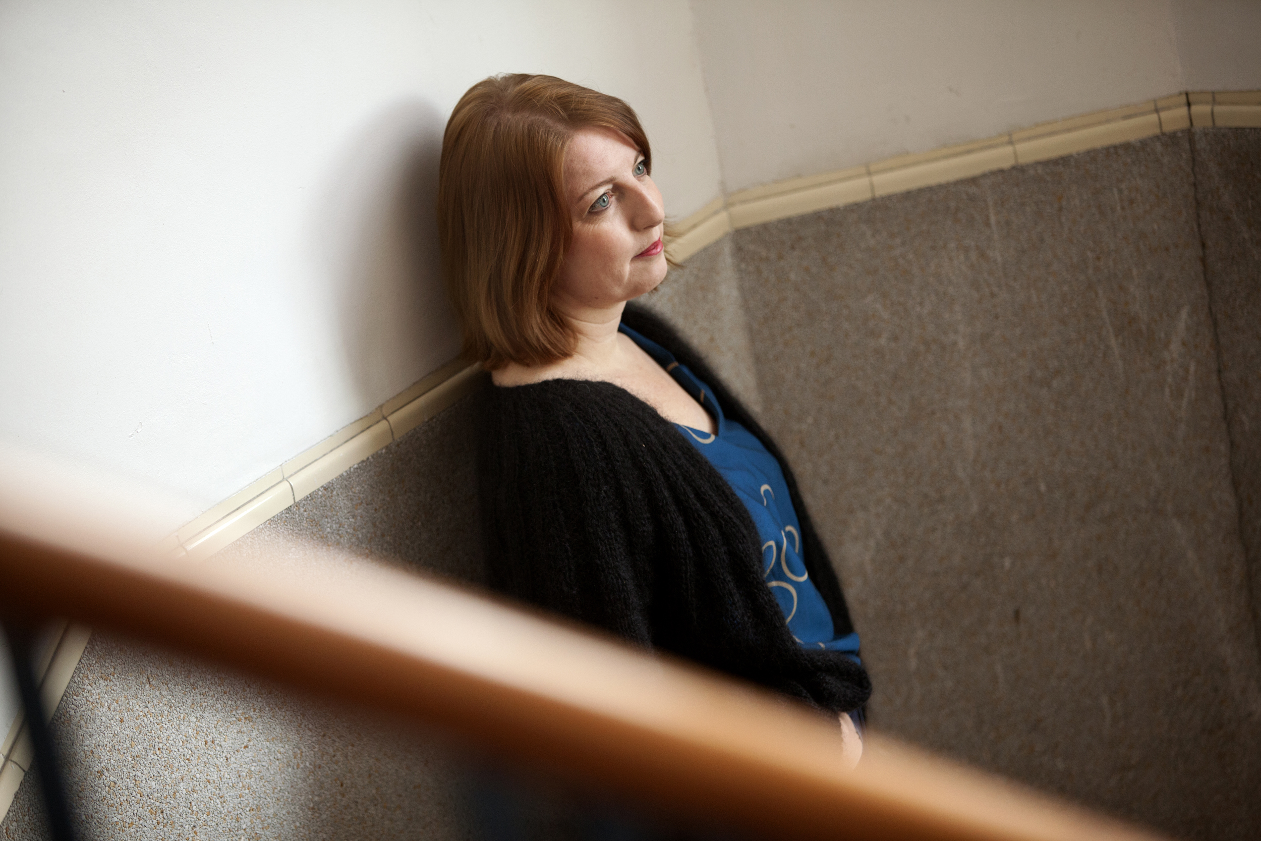 Vrouw staat in trappenhuis tegen muur