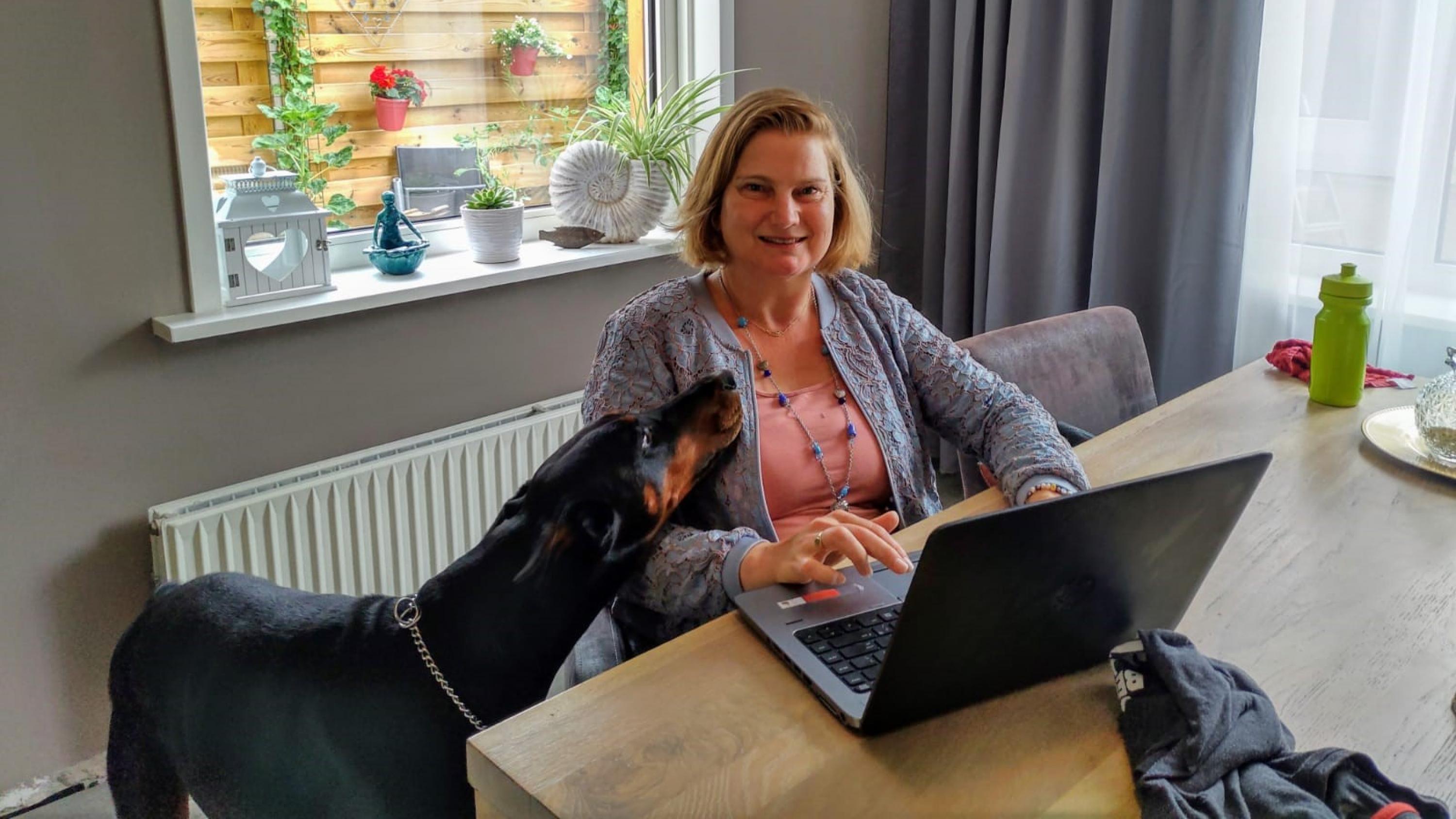 vrouw met laptop aan tafel