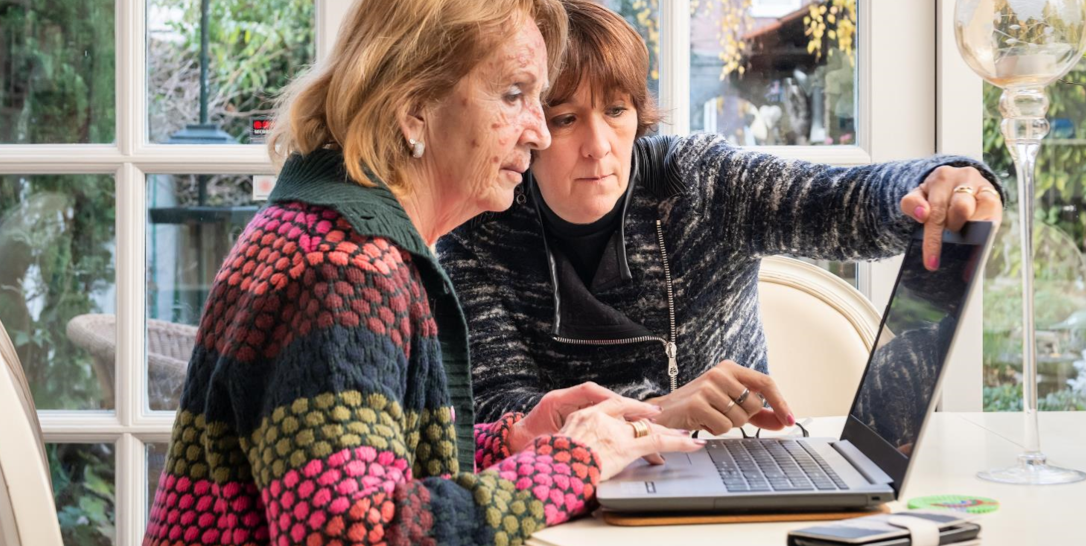 Twee vrouwen achter laptop aan tafel